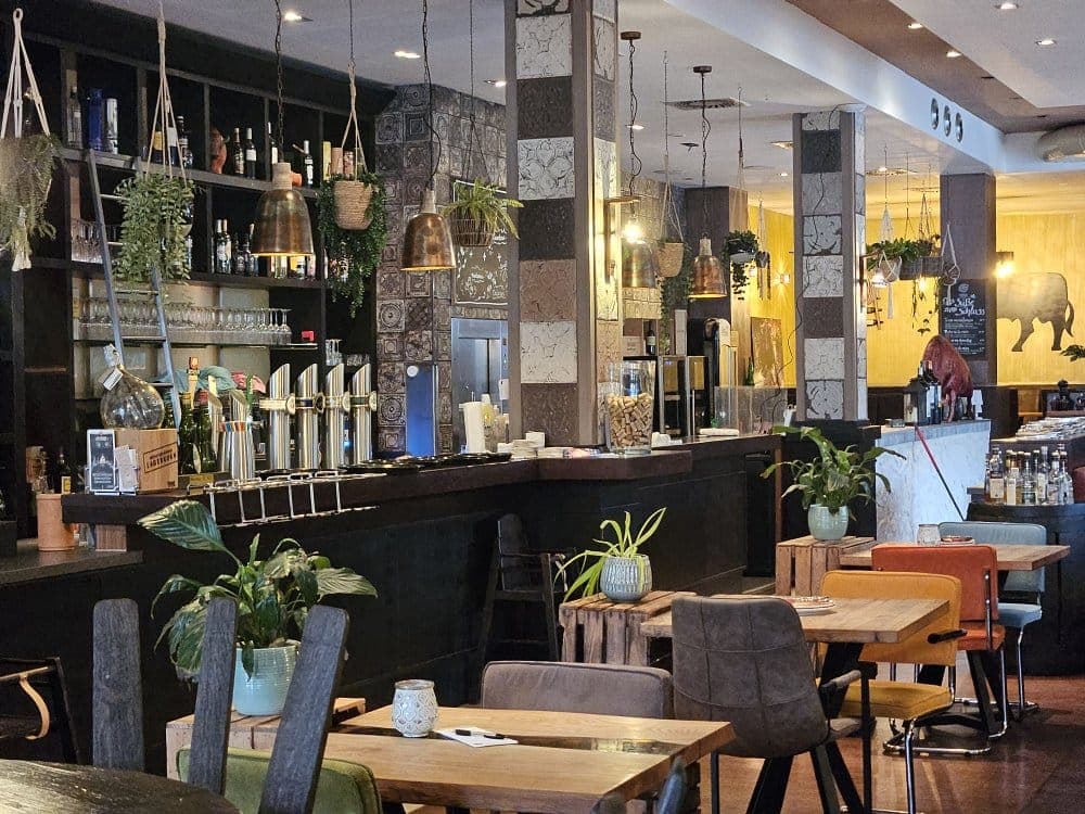 Bar mit Zapfhähnen, Pflanzen und warmem Licht bei La Tapa Guapa